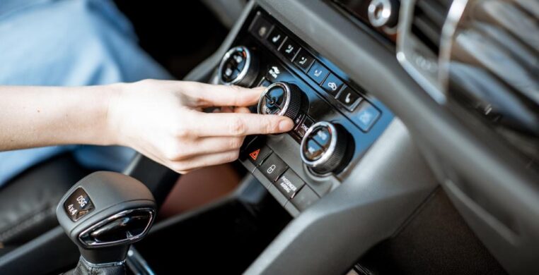 Close-up of a hand pressing the AC button inside a car during car air conditioning repair Nottingham