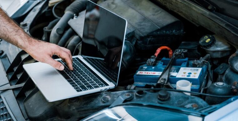 Laptop connected to engine bay for car diagnostics Nottingham.