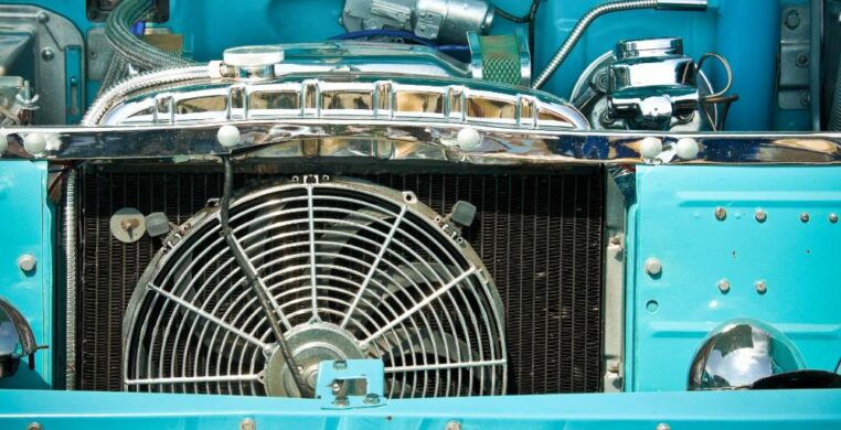 Close-up, inside a garage, of a car radiator repair in Nottingham, showing cooling fins and hoses during a repair to ensure proper engine cooling performance.