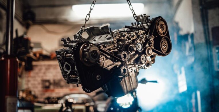Engine lifted on a hydraulic hoist in a garage for professional engine services in Nottingham.